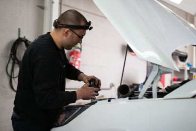 Ouvrier s'occupant de l'entretien d'une voiture d'occasion.