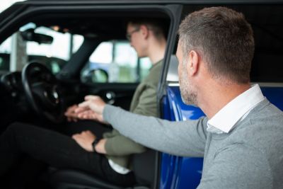 Personne essayant une voiture d'occasion disposant d'une garantie.