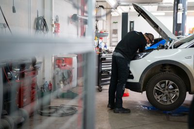 Personne vérifiant les potentiels risques cachés d'une voiture d'occasion sous garantie.