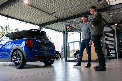 Personne estimant une voiture pour la vendre dans une concession d'occasion.