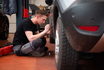 Personne réparant la carrosserie d'une voiture d'occasion.